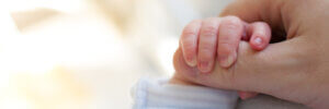 Newborn Baby Touching His Mother Hand