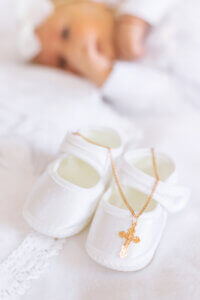 The Sacrament Of The Baptism Of A Child. The Kid Is Holding A Cross. Selective Focus.